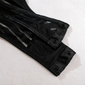 Detailed macro view of the snap-button closure on sparkly black mesh bodysuit with leg rings