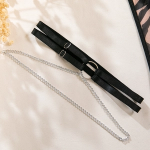 Detail view of black elastic thigh garter with silver metal ring and long chain accessory