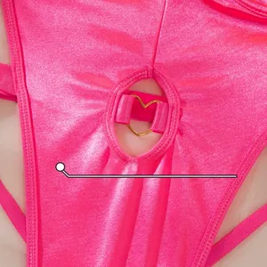 Macro shot of rose pink glitter fabric with a heart-shaped golden metal ring detail