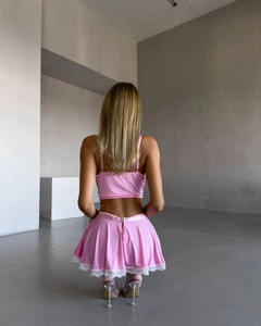 Détail d'un ensemble rose deux pièces avec jupe plissée en dentelle et crop top de dos