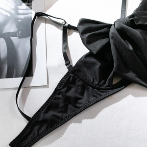 Detailaufnahme der schwarzen Satin-Dessous mit großer Schleife und Trägern