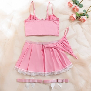 Vue à plat d'un ensemble de lingerie rose avec dentelle incluant jupe, haut et accessoires