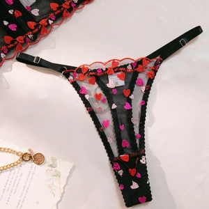 Detail of sheer black lace G-string with red heart embroidery and adjustable straps