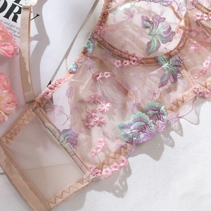 Detail of floral embroidery on sheer mesh corset with pink and purple petals