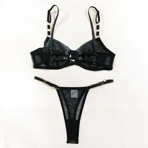 Close-up of black sheer mesh lingerie set with golden metal rings and strappy back details