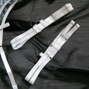 Close-up of white elastic straps with silver metal rings and adjustable buckles detail