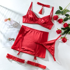 Detailed flat lay of red satin lingerie set with lace accents and matching accessories