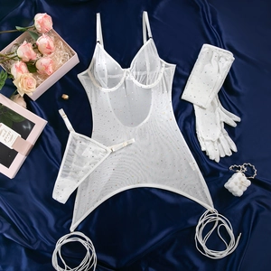 Flat lay of white mesh lingerie set with sparkling sequins on blue silk backdrop