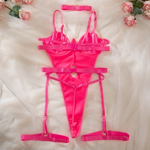 Detailed flat lay of a hot pink lingerie bodysuit with garters and heart hardware