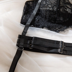 Close-up of black eyelash lace embroidery with adjustable straps and silver metal rings