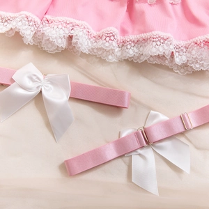 Détail de jarretière en satin rose avec nœud blanc, dentelle et boucle en métal