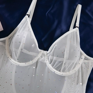 Detail of white mesh bodysuit with iridescent sequins and underwire cups on blue satin