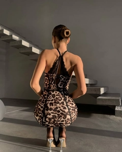 Détail du dos d'une robe léopard avec empiècement en dentelle noire et rubans croisés