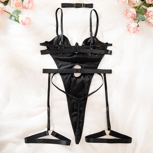 Lingerie detail showing a black satin bodysuit with heart-shaped metal rings and leg garters