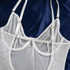 Detail des weißen Mesh-Bodys mit verstellbaren Gold-Schnallen auf blauer Seide