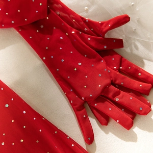 Macro shot of long red sheer mesh gloves embellished with shimmering crystals and rhinestones