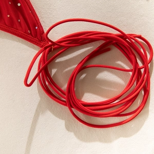 Macro shot of red sequined fabric and slender ties on the glitter mini dress detail