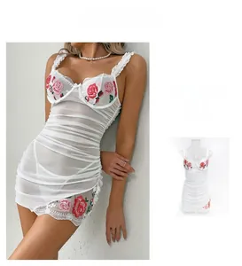 Detailed white lace bodysuit featuring red rose embroidery and ruched mesh texture