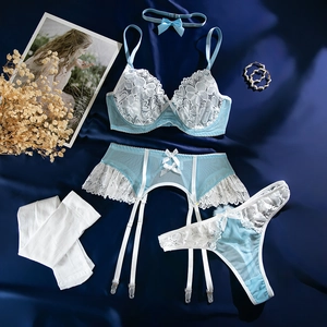 Ensemble de lingerie en dentelle bleu et blanc avec bas et jarretelles sur fond de satin