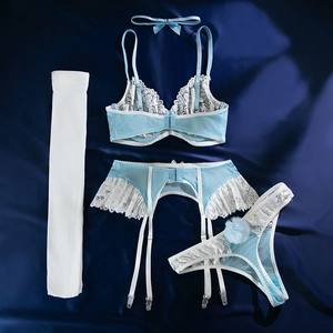 Détails à plat de l'ensemble lingerie en dentelle bleu clair avec bas et pompons