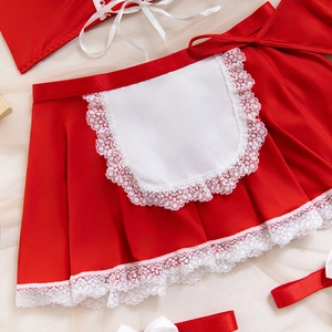 Détail d'une jupe festive rouge avec bordure en dentelle blanche et nœud en ruban
