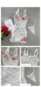 Detail of white lace lingerie set with red rose embroidery and ruched mesh texture