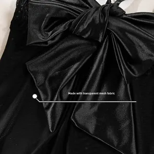 Detail of black satin bow with lace trim and transparent mesh fabric on sexy lingerie