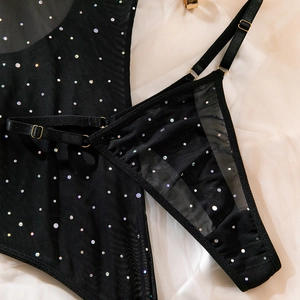 Close-up of black mesh lingerie with rainbow rhinestones and gold adjustable buckles