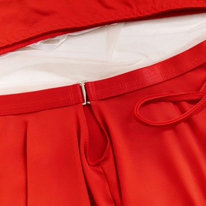 Détail du costume rouge festif avec fermeture à crochet en métal et doublure en tulle