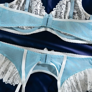 Détail de body en dentelle bleu clair avec broderie blanche et bretelles de soutien-gorge