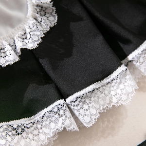 Vue macro détaillée du tissu en satin noir avec bordure en dentelle blanche délicate