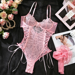 Pink lace bodysuit featuring underwire cups and crisscross tie details on black silk background