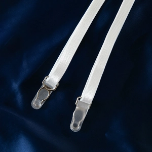 Détail de porte-jarretelles blancs réglables avec crochets en métal sur fond de soie bleue