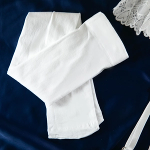 Détail de bas de lingerie en tricot blanc sur un tissu en satin bleu élégant