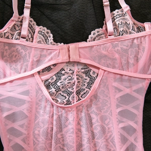 Detailed view of pink lace embroidery and mesh fabric with adjustable thin straps
