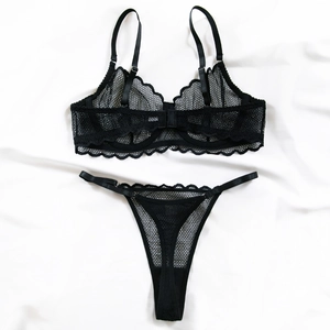 Gros plan sur les broderies en dentelle noire et le tulle transparent de cet ensemble