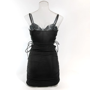 Detail of black mini dress featuring drawstring side ties and pleated fabric texture on the back