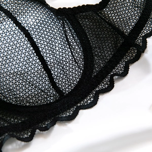 Détail du soutien-gorge en dentelle noire avec texture en nid d'abeille et bords festonnés