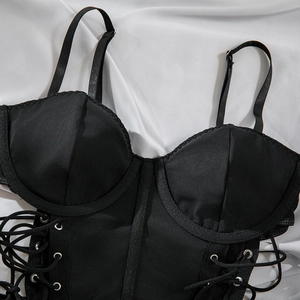 Detail of black corset dress featuring wired cups, adjustable straps, and side lace-up eyelets
