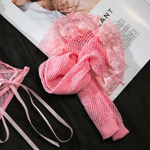 Detailed close-up of pink fishnet stockings with layered lace trim and pearl accents