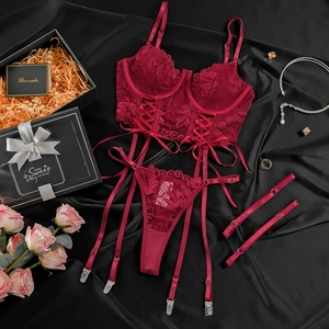 Flat lay of wine red lace lingerie set with underwire top and garter belts on black silk