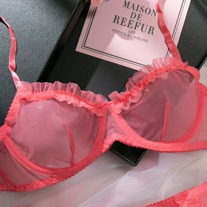 Detail of pink sheer mesh lingerie set with ruffled trim and delicate straps in a gift box