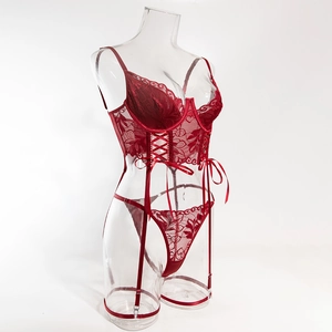 Detailed view of red lace lingerie set with corset lacing and satin bows on a mannequin