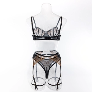 Detail of sheer black mesh lingerie set with intricate gold chain wave embroidery