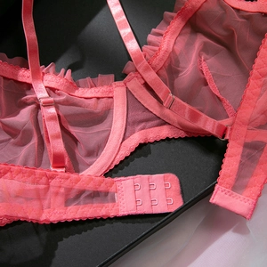 Detailed macro view of pink mesh bra featuring pleated lace edges and adjustable straps