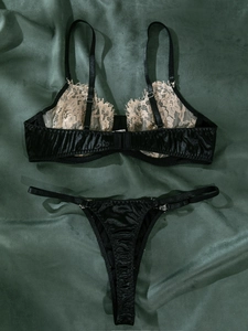 Détail de l'ensemble lingerie en satin noir avec dentelle de cils sur fond de velours