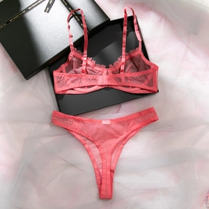 Detailed flat lay of a coral pink sheer mesh lingerie set with ruffle trim and gift box