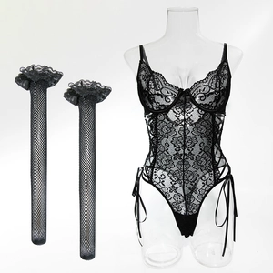 Detail of black lace bodysuit featuring cross straps and matching fishnet stockings