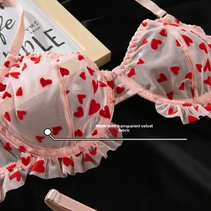 Détail d'un soutien-gorge en tulle rose avec coeurs floqués et bords volantés