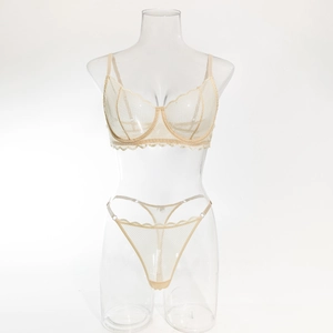 Détail d'un ensemble de lingerie en dentelle nude avec broderies et tulle sur mannequin clair